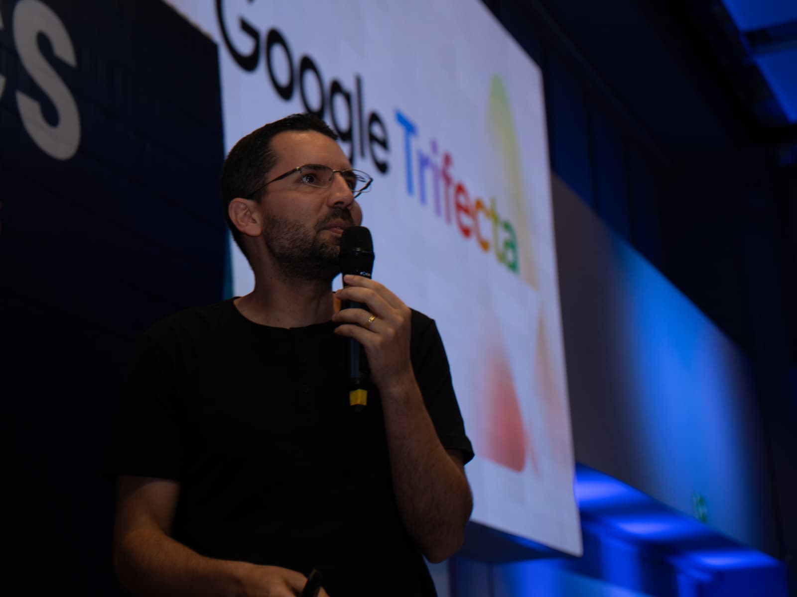 Vinícius Zimmer palestrando no Analytics Summit, com o telão do Google ao fundo.
